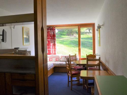 une salle à manger avec une table et des chaises et une fenêtre dans l'établissement ### Titre proposé : Studio 5 pers, skis aux pieds, proche commerces et pistes, Charvet Arc 1800 - FR-1-411-470, à Arc 1800