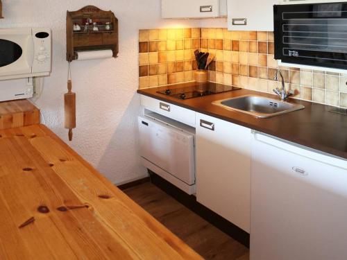 une petite cuisine avec un évier et un micro-ondes dans l'établissement Studio confort au pied des pistes Les Orres 1650 - 4 pers - Animaux admis - FR-1-322-320, aux Orres