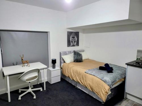 a bedroom with a bed and a desk and a table at Easy Living Nottingham - Burns Street in Nottingham