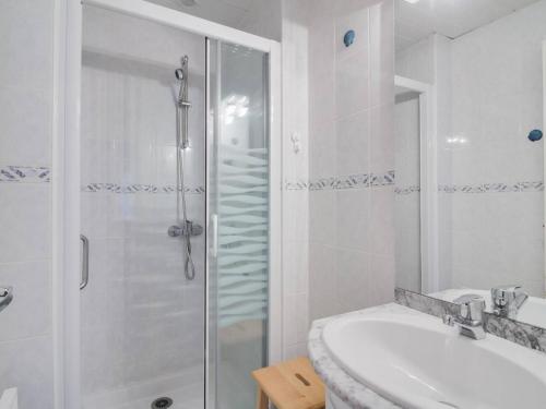une salle de bain blanche avec une douche et un lavabo dans l'établissement Appartement 2 pièces, centre de Cauterets, proche télécabine, local ski, bien équipé - FR-1-401-110, à Cauterets