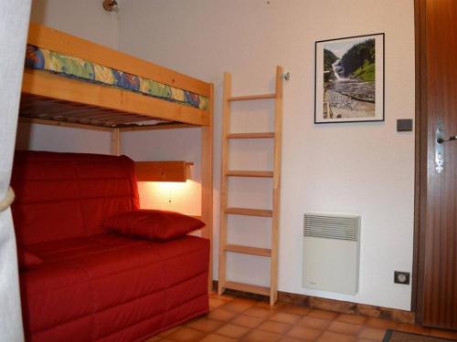 1 dormitorio con 2 literas y sofá rojo en Appartement Le Grand-Bornand, 2 pièces, 5 personnes - FR-1-241-198, en Le Grand-Bornand