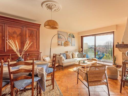 un salon avec un canapé, une table et des chaises dans l'établissement Duplex de caractère 4 chambres avec balcon, près du centre et des commerces, parking inclus - FR-1-4-526, à Saint-Jean-de-Luz