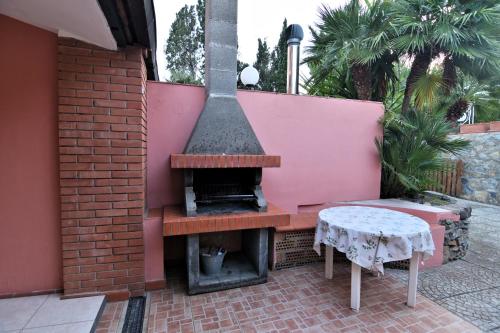 a outdoor fireplace with a table next to a brick wall at Villa Very in Marina di Campo