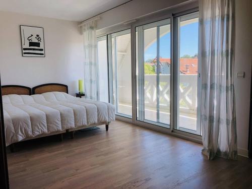 une chambre avec un lit et une grande fenêtre dans l'établissement Appartement 4 chambres avec terrasse et parking à Arcachon, accès direct aux plages - FR-1-433-28, à Arcachon