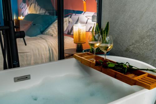 a bath tub with two glasses of wine in it at Milano Experience Home - Gauguin in Milan