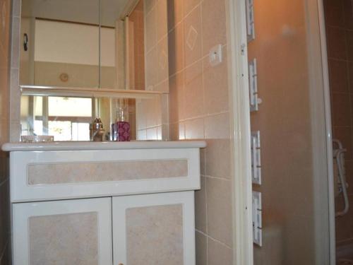 La salle de bains est pourvue d'une armoire blanche et d'un miroir. dans l'établissement Villa climatisée 3 pièces, 6 couchages avec terrasse, piscine et parking à Saint-Cyprien - FR-1-225D-532, à Saint Cyprien Plage