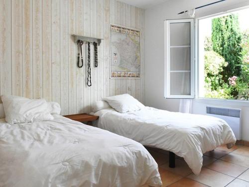 two beds in a room with a window at Maison Les Portes-en-Ré, 4 pièces, 6 personnes - FR-1-434-10 in Les Portes