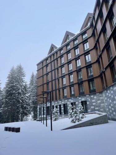 a large building with snow in front of it at Woodside Kopaonik 417-418 in Kopaonik
