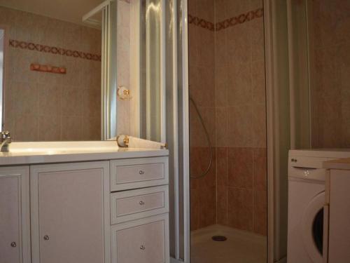 La salle de bains est pourvue d'un lavabo, d'une douche et d'un lave-linge. dans l'établissement Maison cosy avec mezzanine, terrasse, piscine et parking – Saint-Cyprien - FR-1-225D-558, à Saint Cyprien Plage