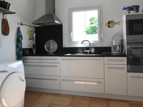 a white kitchen with a sink and a window at Maison spacieuse avec jardin, cheminée, internet et lits faits à l'arrivée - Les Portes-en-Ré - FR-1-434-10 in Les Portes
