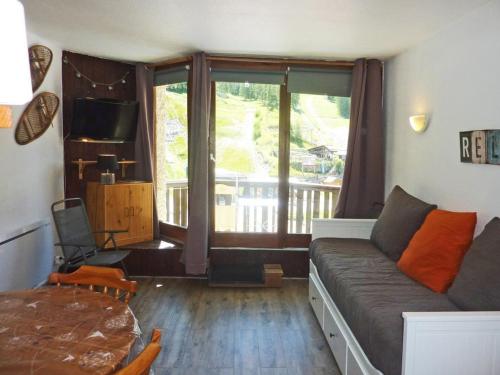 un salon avec un canapé et une grande fenêtre dans l'établissement Studio rénové, skis aux pieds, balcon sud - FR-1-322-319, aux Orres