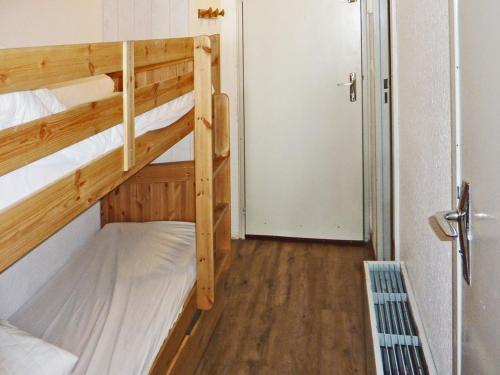 Cette chambre comprend 2 lits superposés et une porte. dans l'établissement Studio rénové, skis aux pieds, balcon sud - FR-1-322-319, aux Orres