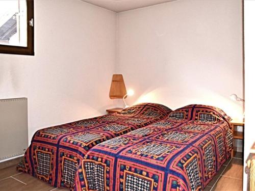 a bedroom with a bed with a colorful bedspread at Appartement Montgenèvre, 4 pièces, 8 personnes - FR-1-266-129 in Montgenèvre