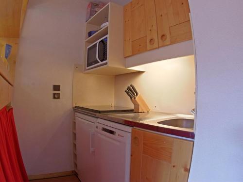 une petite cuisine avec un évier et un micro-ondes dans l'établissement Confortable Appartement de 2P avec Balcon, Acceptant Animaux à Valmorel - FR-1-291-815, à Valmorel