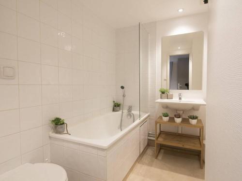 une salle de bain avec une baignoire, des toilettes et un lavabo dans l'établissement Studio rénové pour 4 pers. avec piscine, sauna et balcon à Saint-Lary-Soulan - FR-1-296-257, à Saint-Lary-Soulan