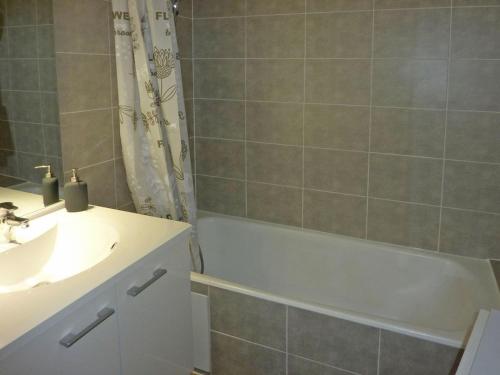 uma casa de banho com um lavatório, uma banheira e um chuveiro em Appartement Les Orres, 2 pièces, 6 personnes - FR-1-322-311 em Les Orres