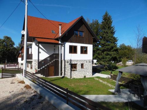 ein Haus mit rotem Dach in der Unterkunft Guesthouse Family Bosnic in Plitvička Jezera