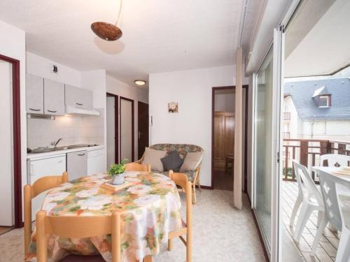 une salle à manger avec une table et une cuisine dans l'établissement Appartement ensoleillé 4 pers, proche thermes et télécabine, avec balcon et parking, Saint-Lary-Soulan - FR-1-296-264, à Saint-Lary-Soulan