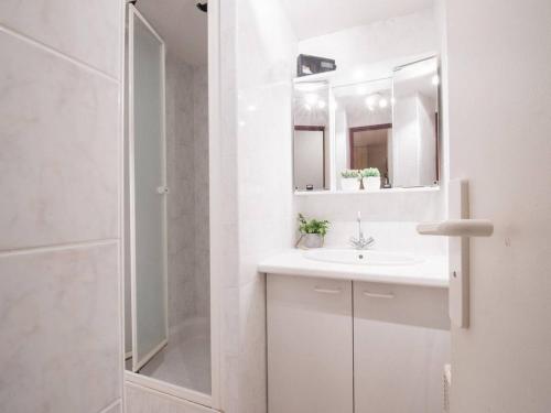 une salle de bain blanche avec un lavabo et une douche dans l'établissement Appartement ensoleillé 4 pers, proche thermes et télécabine, avec balcon et parking, Saint-Lary-Soulan - FR-1-296-264, à Saint-Lary-Soulan