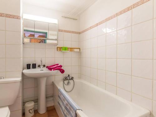 y baño blanco con lavabo y bañera. en Appartement Le Monêtier-les-Bains, 3 pièces, 6 personnes - FR-1-330F-138, en Le Monêtier-les-Bains