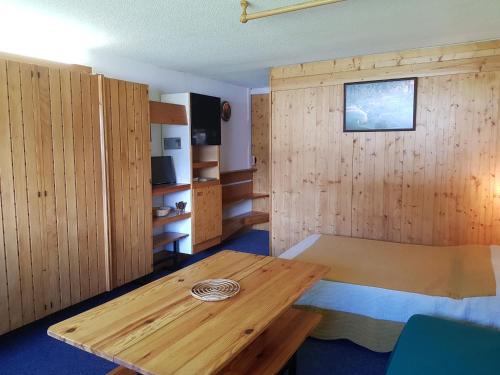 Cette chambre est dotée de murs en bois et d'une table en bois. dans l'établissement Studio confortable à Arc 1600, ski aux pieds, proche commerces, pour 3 personnes - FR-1-411-530, à Arc 1600