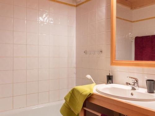 W łazience znajduje się umywalka, wanna i lustro. w obiekcie Appartement Le Monêtier-les-Bains, 3 pièces, 7 personnes - FR-1-330F-146 w mieście Le Monêtier-les-Bains