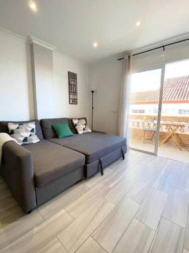 a living room with a couch and a large window at Beach apartment LA CALA DE MIJAS in La Cala de Mijas