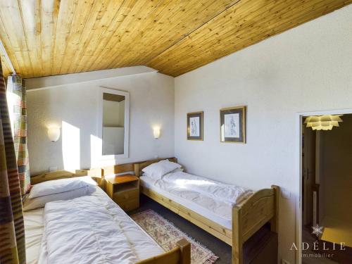 1 Schlafzimmer mit 2 Betten und Holzdecke in der Unterkunft Appartement Montvalezan-La Rosière, 3 pièces, 6 personnes - FR-1-398-519 in La Rosière
