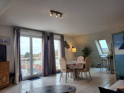 d'un salon avec une table et un balcon. dans l'établissement Appartement 2 pièces avec piscine et parking privé, proche plage, Merville-Franceville-Plage - FR-1-465-26, à Merville-Franceville-Plage