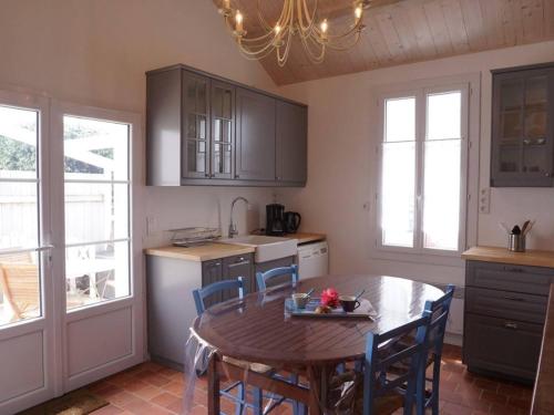 une cuisine avec une table et des chaises en bois ainsi qu'une table et une salle à manger dans l'établissement Maison de plain-pied avec cour, proche plage et commerces - 4 couchages, Noirmoutier-en-l'Île - FR-1-224B-675, à Noirmoutier-en-l'lle