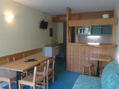 une cuisine et une salle à manger avec une table et des chaises dans l'établissement Studio skis aux pieds, proche commerces, balcon exposé Sud-Ouest - FR-1-411-549, à Arc 1800