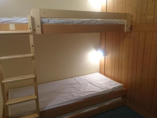 une petite pièce avec deux lits superposés dans l'établissement Studio skis aux pieds, proche commerces, balcon exposé Sud-Ouest - FR-1-411-549, à Arc 1800