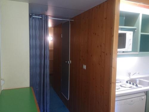 Il comprend une petite cuisine équipée d'une douche et d'un four micro-ondes. dans l'établissement Studio skis aux pieds, proche commerces, balcon exposé Sud-Ouest - FR-1-411-549, à Arc 1800