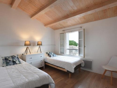 萊斯波特斯的住宿－Maison Les Portes-en-Ré, 4 pièces, 6 personnes - FR-1-434-59，一间卧室设有两张床和窗户。