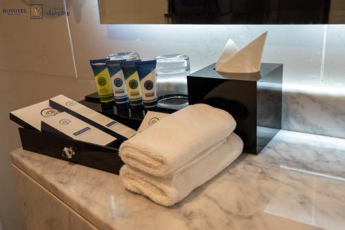 einen Haufen Handtücher auf einer Theke im Bad in der Unterkunft Romera Hotel in Dschidda