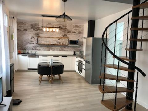 - une cuisine avec une table et un escalier dans une chambre dans l'établissement Maison des rencontres amicales, au Crotoy
