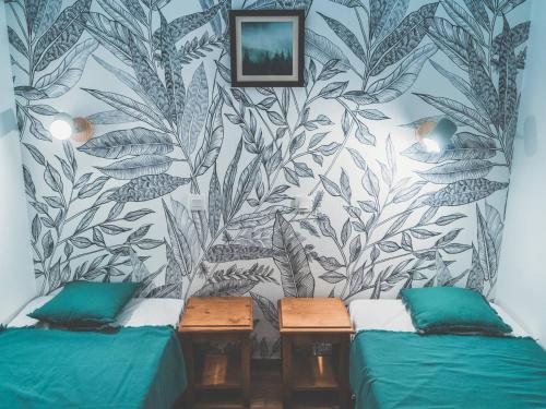 Cette chambre comprend 2 lits et un mur orné d'une fresque murale. dans l'établissement Appartement cosy 6 pers avec piscine, sauna et accès direct aux pistes - Les Orres 1800 - FR-1-322-329, aux Orres