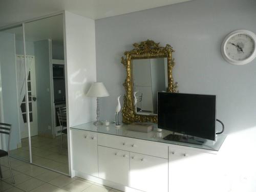 - un salon avec une télévision et un miroir dans l'établissement Quiberon - Studio rénové 28m² - Terrasse sud - Garage privé - FR-1-478-41, à Quiberon