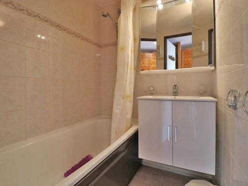 uma casa de banho com um lavatório, uma banheira e um espelho. em Studio Montvalezan-La Rosière, 1 pièce, 4 personnes - FR-1-398-563 em La Rosière
