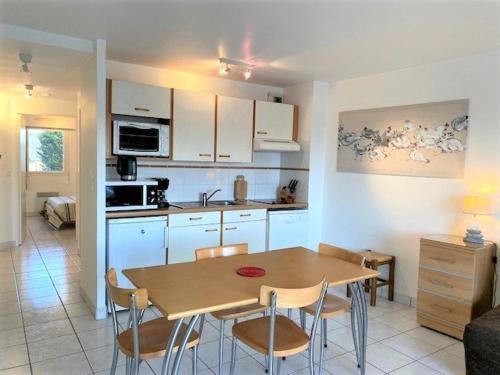 une cuisine et une salle à manger avec une table et des chaises dans l'établissement Quiberon - Appartement 2 pièces - 4 pers, balcon, parking - FR-1-478-77, à Quiberon