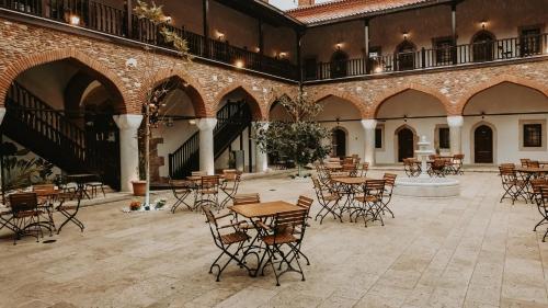 a courtyard with tables and chairs in a building at Fibar Hotel Zincirlihan in Aydın