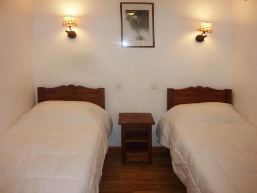 - 2 lits dans une chambre avec 2 lumières sur le mur dans l'établissement Charmant 2 pièces avec piscine chauffée et balcon sud, au pied des pistes - Les Orres 1800 - FR-1-322-333, aux Orres