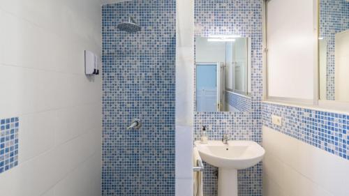 a blue tiled bathroom with a sink and a mirror at Casa rural cerca de Aracena Castillo de las Guardas by Ruralidays in Seville