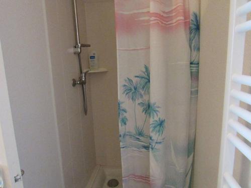 a shower curtain with palm trees on it in a bathroom at Appartement Étel, 2 pièces, 4 personnes - FR-1-479-88 in Étel
