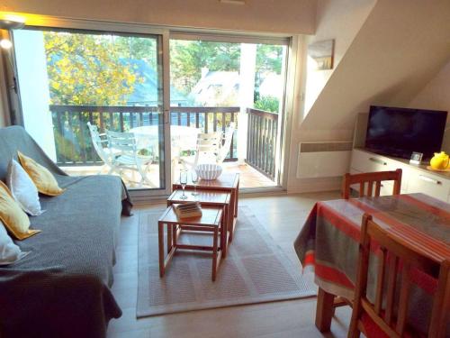 d'un salon avec un canapé et une table ainsi que d'un balcon. dans l'établissement Appartement duplex 3 pièces à 300m de la plage avec parking, balcon et équipements modernes - FR-1-477-51, à Carnac