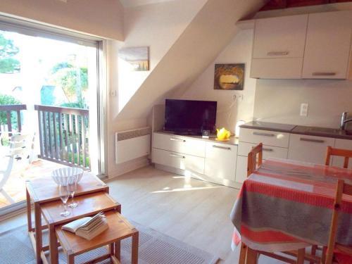 a kitchen and dining room with a table and a television at Appartement Carnac, 3 pièces, 5 personnes - FR-1-477-51 in Carnac
