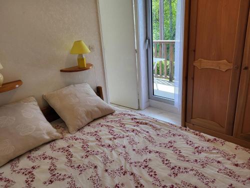 a bedroom with a bed and a window and a lamp at Appartement Cabourg, 2 pièces, 4 personnes - FR-1-465-16 in Cabourg
