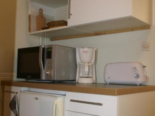 un comptoir de cuisine avec un four micro-ondes et un mixeur dans l'établissement Appartement 2 pièces au pied des pistes, balcon, casier à ski, parking gratuit - FR-1-557-62, à Les Adrets