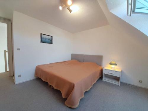 - une chambre avec un lit et une table de chevet avec une lampe dans l'établissement Appartement Carnac, 3 pièces, 4 personnes - FR-1-477-73, à Carnac