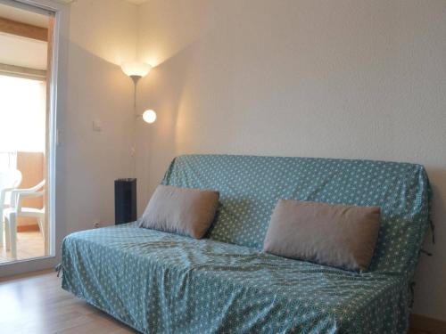 - un canapé avec deux oreillers dans l'établissement Appartement 2 pièces avec climatisation et parking à Banyuls-sur-Mer - FR-1-225C-12, à Banyuls-sur-Mer